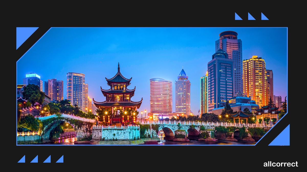 Traditional Chinese architecture with modern skyscrapers in the background at dusk.