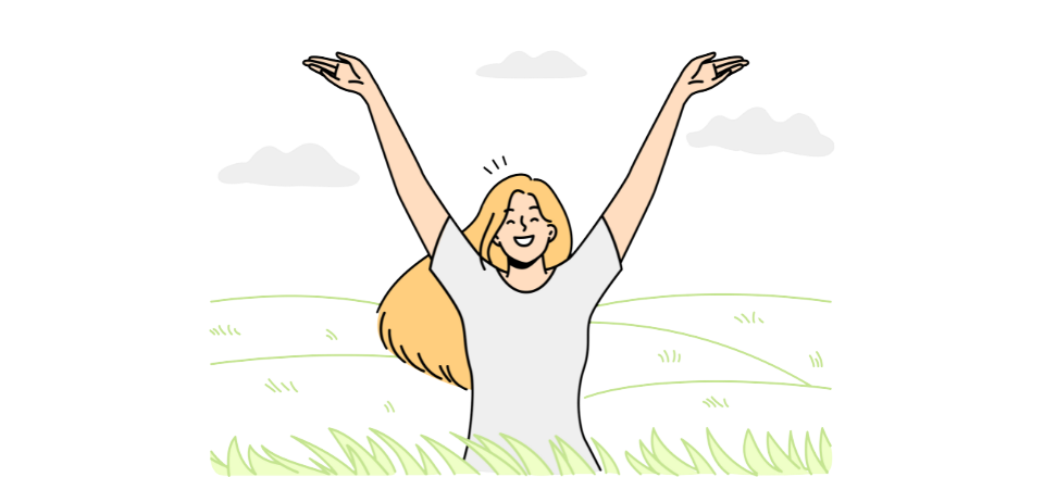 A girl stands in a field and raises her hands joyfully to the sky